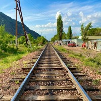 'Trackside in Uchuruk' by Barney Crawford. A view down a railway track with trees and buildings either side