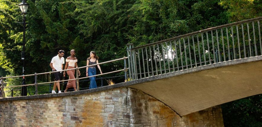 Three University of Cambridge students walking on Garrett Hostel towards the bridge. Copyright: University of Cambridge (June 2023)
